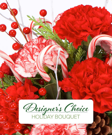 Designer’s Choice Holiday Bouquet featuring festive flowers, holiday greens, and a unique Christmas keepsake container.