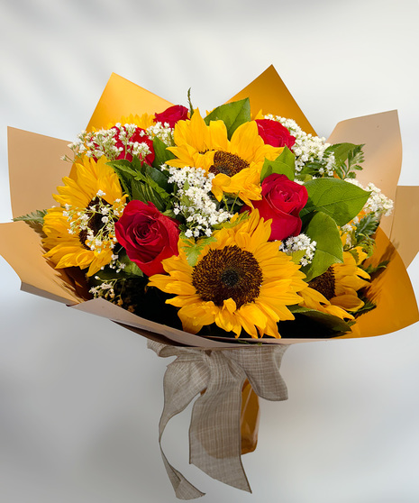 Rose & Sunflower Bouquet featuring red roses, sunflowers, baby's breath, and greenery, wrapped in matching paper and bow.