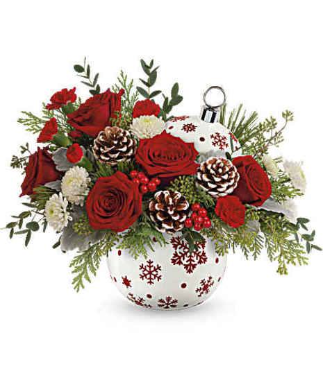 Sprinkle Sparkle Bouquet featuring red roses, mini-carnations, white button mums, pinecones, cedar, and dusty miller in a red snowflake ornament vase.